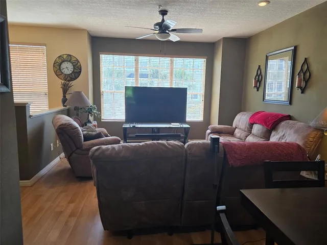 a living room with furniture a window and a flat screen tv
