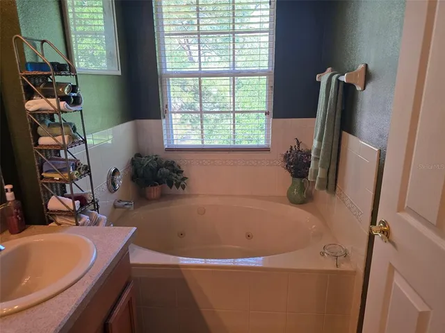 a bathroom with a tub a sink and a window