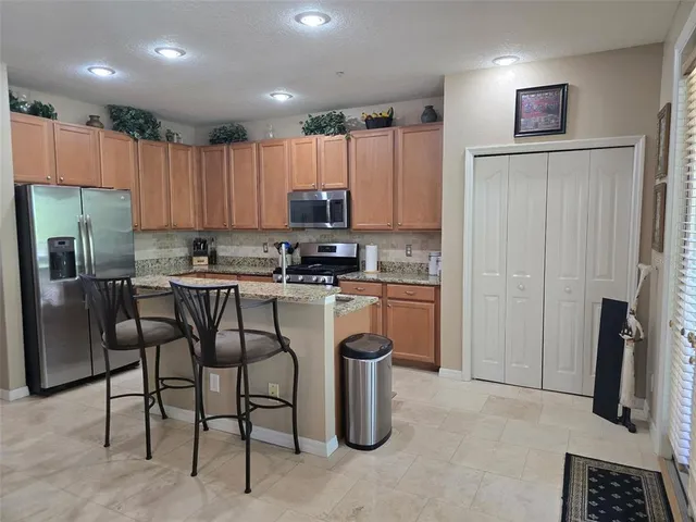 a kitchen with a refrigerator and a stove top oven