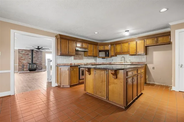 a kitchen with stainless steel appliances granite countertop a stove a sink and a refrigerator