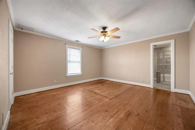 an empty room with wooden floor and window