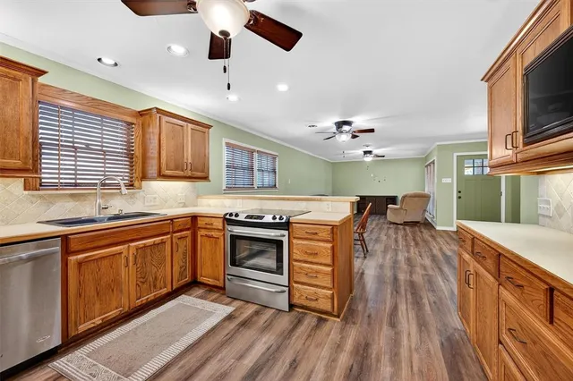 a kitchen with stainless steel appliances granite countertop a sink stove and refrigerator