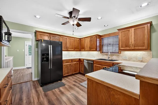 a kitchen with a refrigerator a sink and cabinets