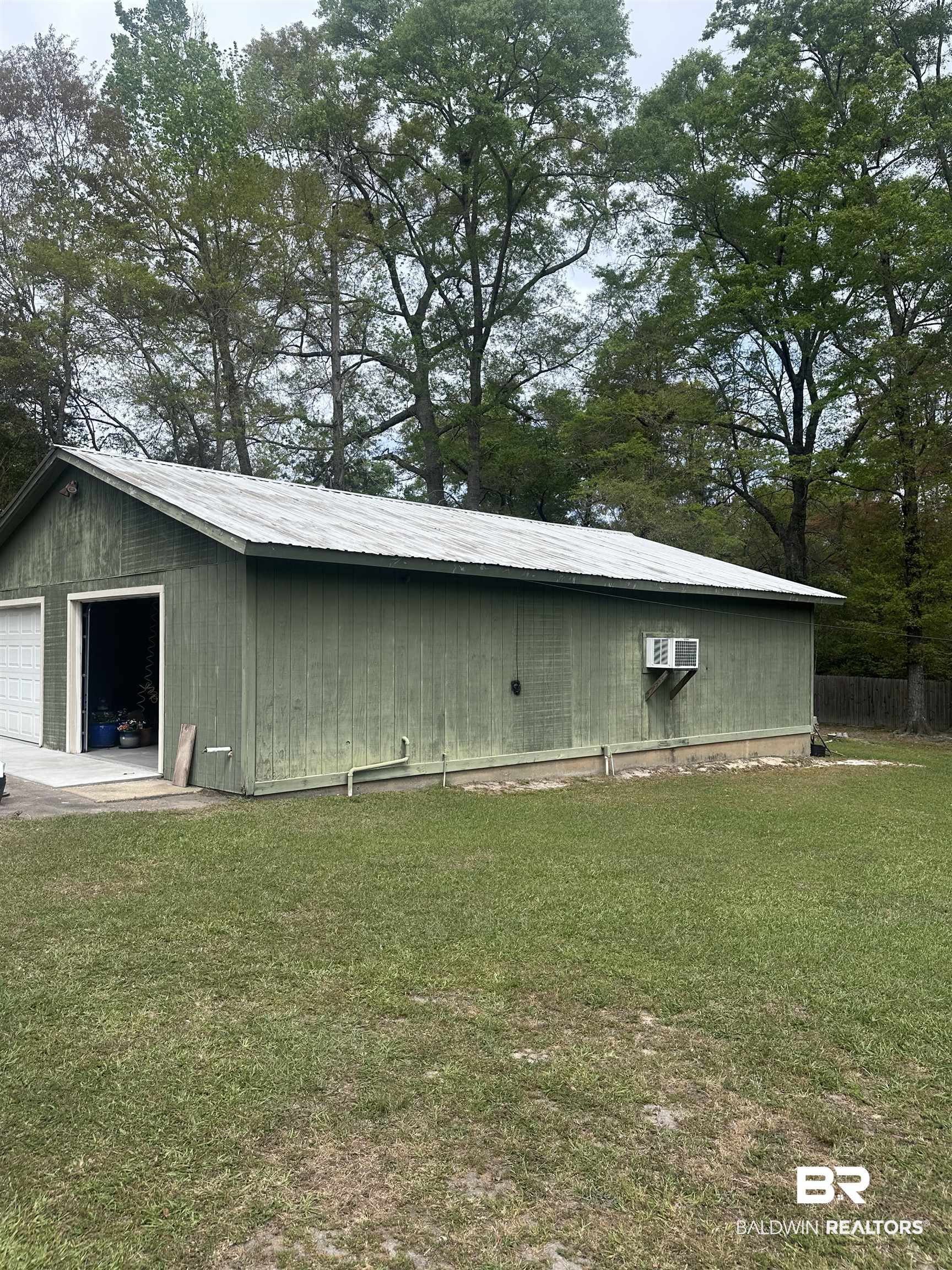 2785 Sowell Road Brewton, AL 36426 - Photo 18 of 24 View of side of property featuring a metal roof, a yard, and an outbuilding