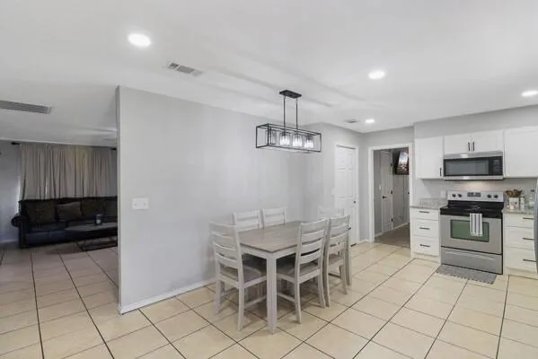 a kitchen with granite countertop a refrigerator and a stove top oven