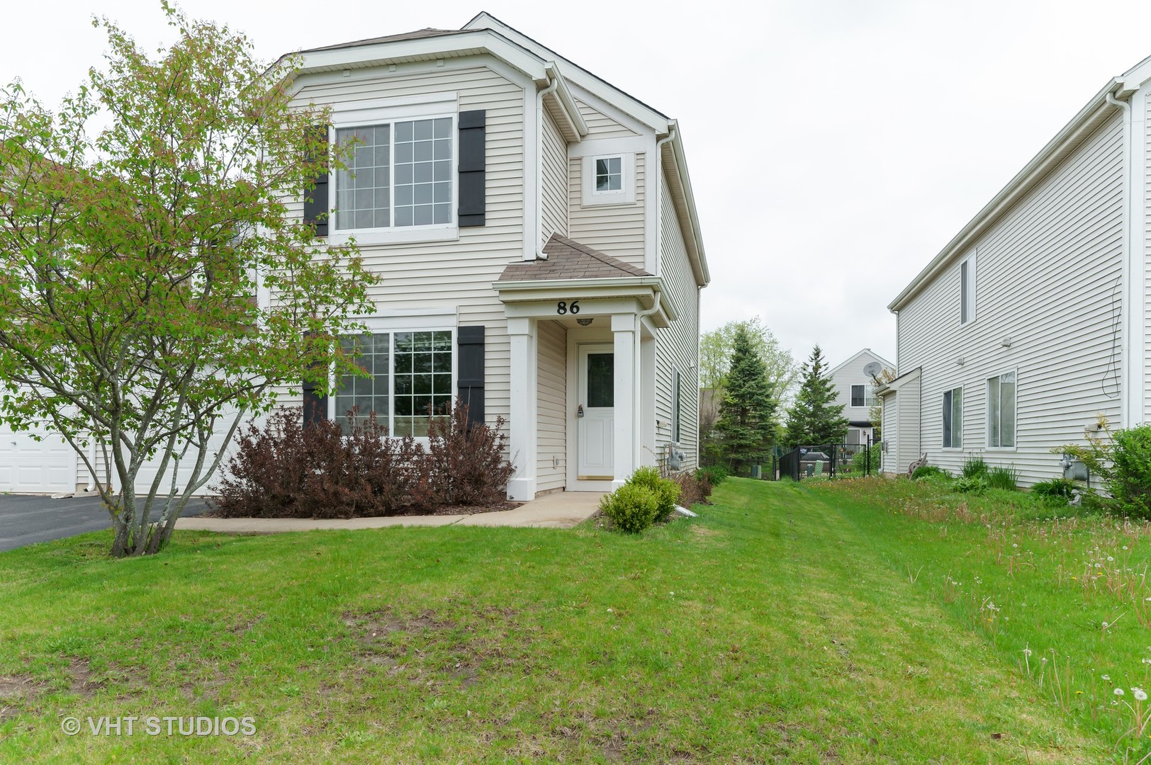 86 Amberly Drive Round Lake, IL 60073 - Photo 1 of 12 a front view of a house with a garden and trees