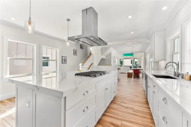 a kitchen with stainless steel appliances kitchen island granite countertop a stove and a sink