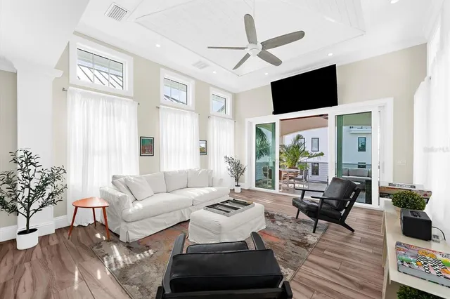 a living room with furniture a flat screen tv and a large window