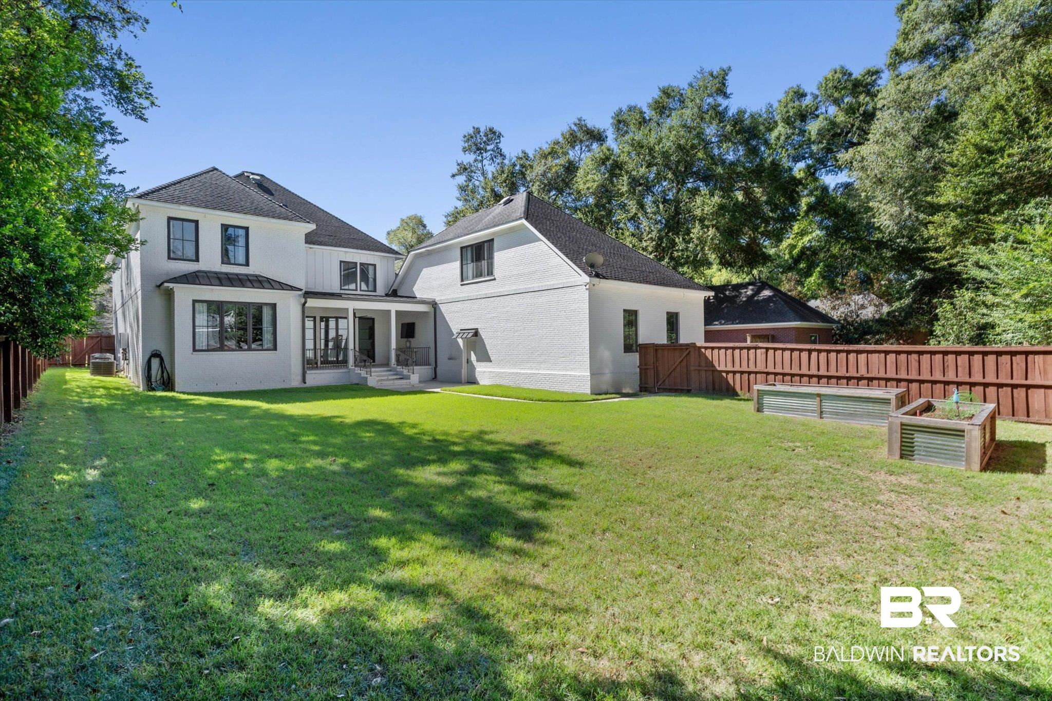 4602 Kingswood Drive Mobile, AL 36608 - Photo 39 of 45 Rear view of property with a fenced backyard, a standing seam roof, a metal roof, a vegetable garden, and a patio area