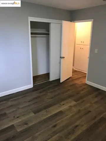 an empty room with wooden floor and closet