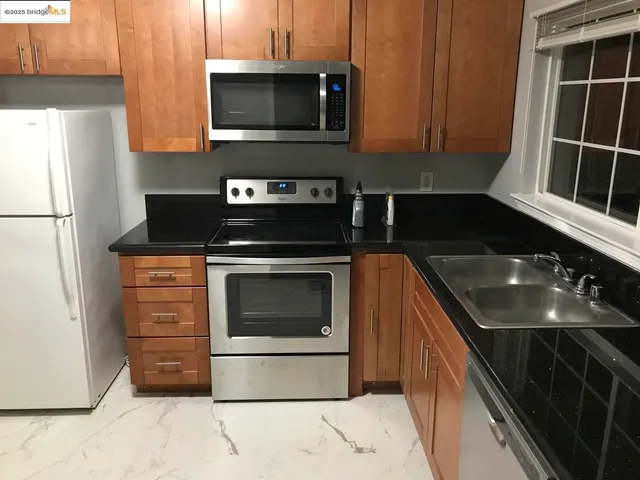 a kitchen with stainless steel appliances granite countertop a stove microwave and refrigerator