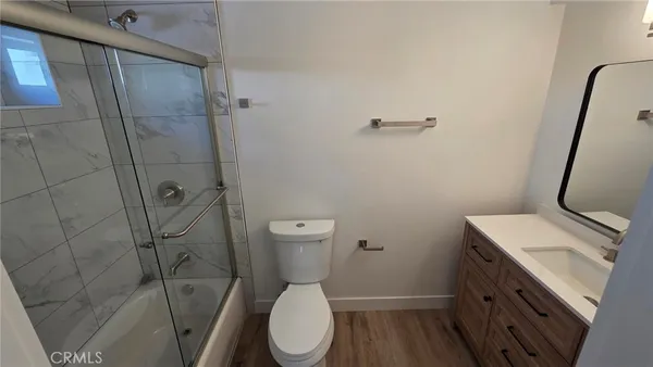 a white toilet sitting next to a bathroom sink and vanity