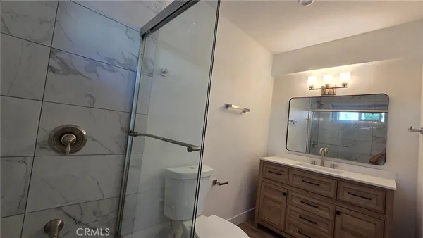 a bathroom with a shower sink and mirror