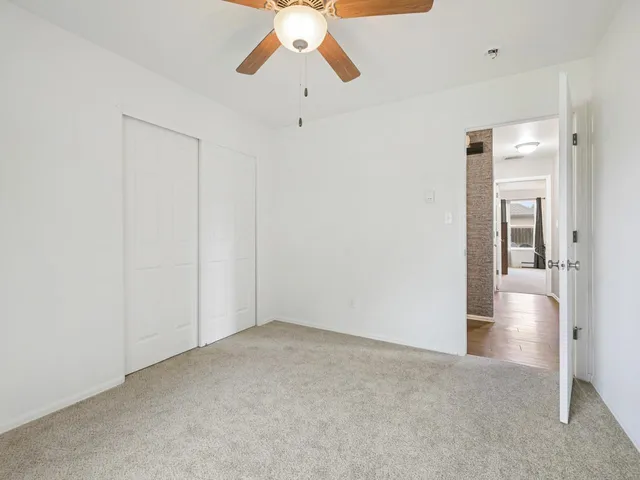 an empty room with a empty space and chandelier fan