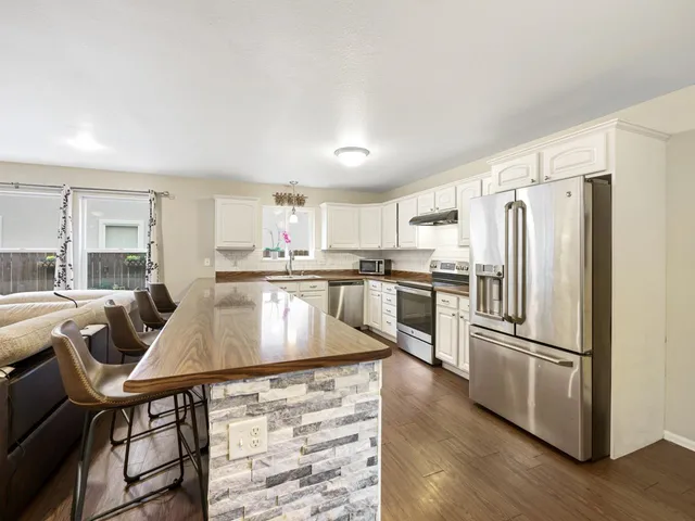 a kitchen with kitchen island white cabinets and stainless steel appliances
