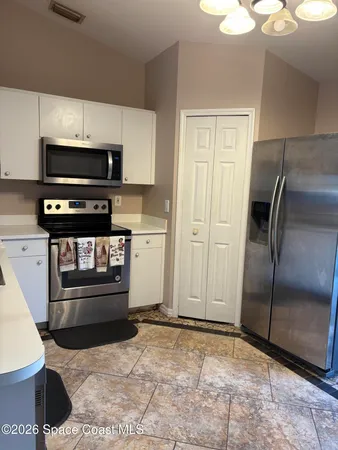 a kitchen with stainless steel appliances kitchen island granite countertop a refrigerator and a stove top oven