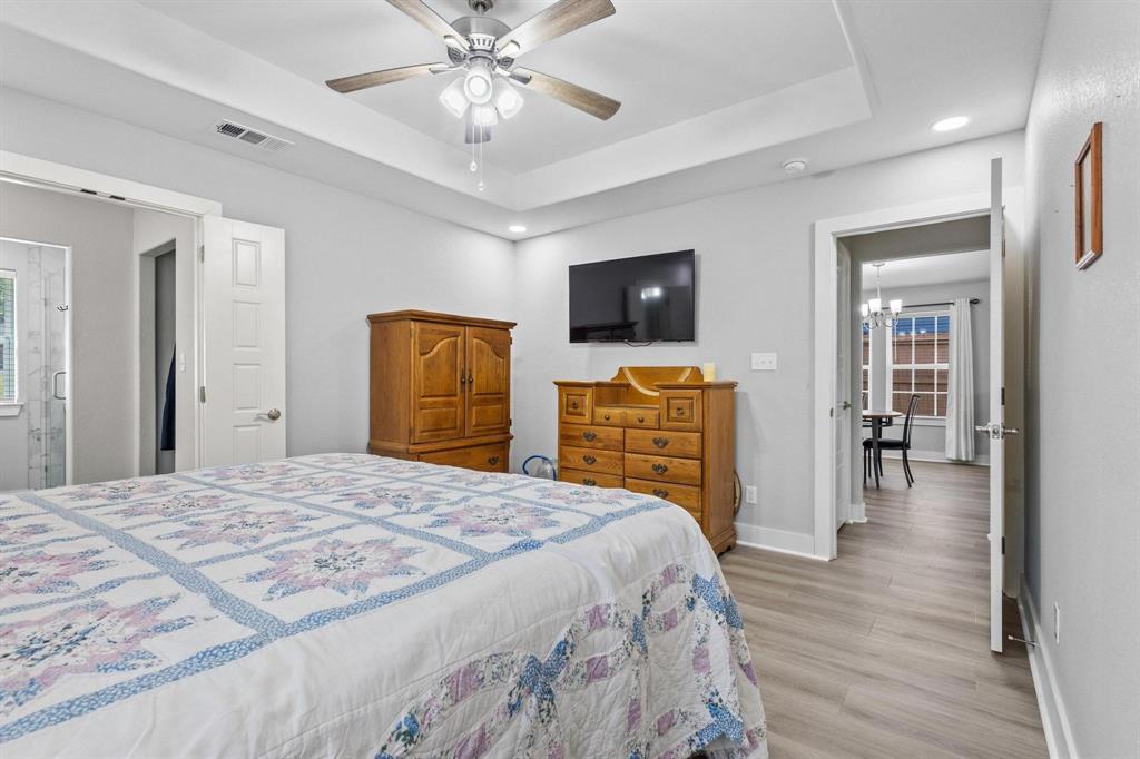 608 East Shepherd Street Denison, TX 75021 - Photo 19 of 31 Spacious room featuring tray ceilings with a ceiling fan, recessed lighting, wood-finish flooring, and light gray walls