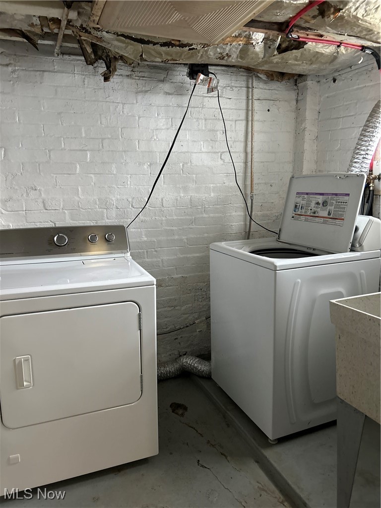11406 Bellaire Road Cleveland, OH 44111 - Photo 22 of 28 Laundry room with independent washer and dryer and concrete block wall