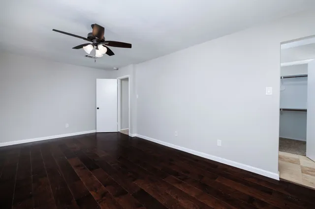 a view of an empty room with wooden floor