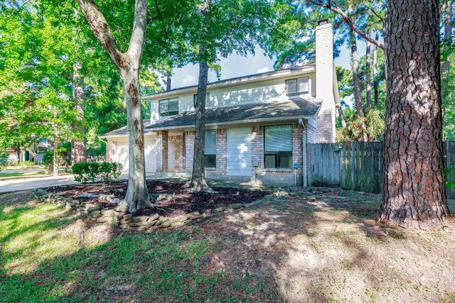 a view of a house with a tree in the forest