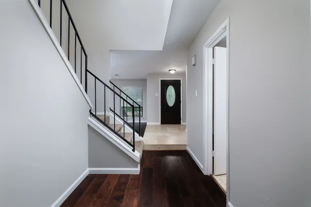 a view of staircase with wooden floor and white walls