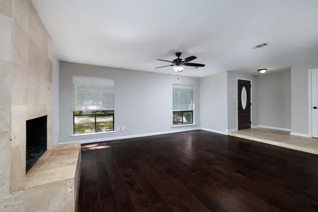 a view of an empty room with a fireplace and a window