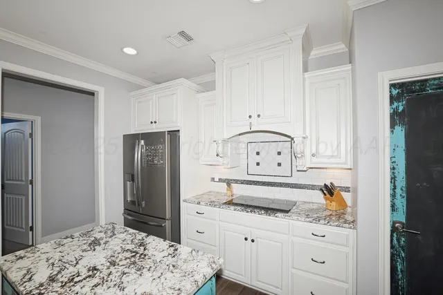 a kitchen with white cabinets and refrigerator