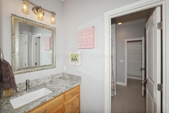 a bathroom with a granite countertop sink a vanity and a mirror