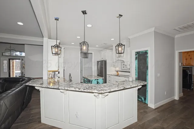 a kitchen with stainless steel appliances granite countertop a sink a counter top space cabinets and wooden floor