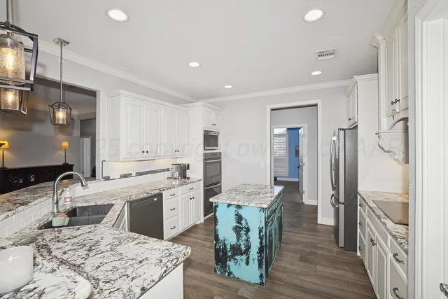 a kitchen with stainless steel appliances granite countertop a sink a stove a refrigerator and island