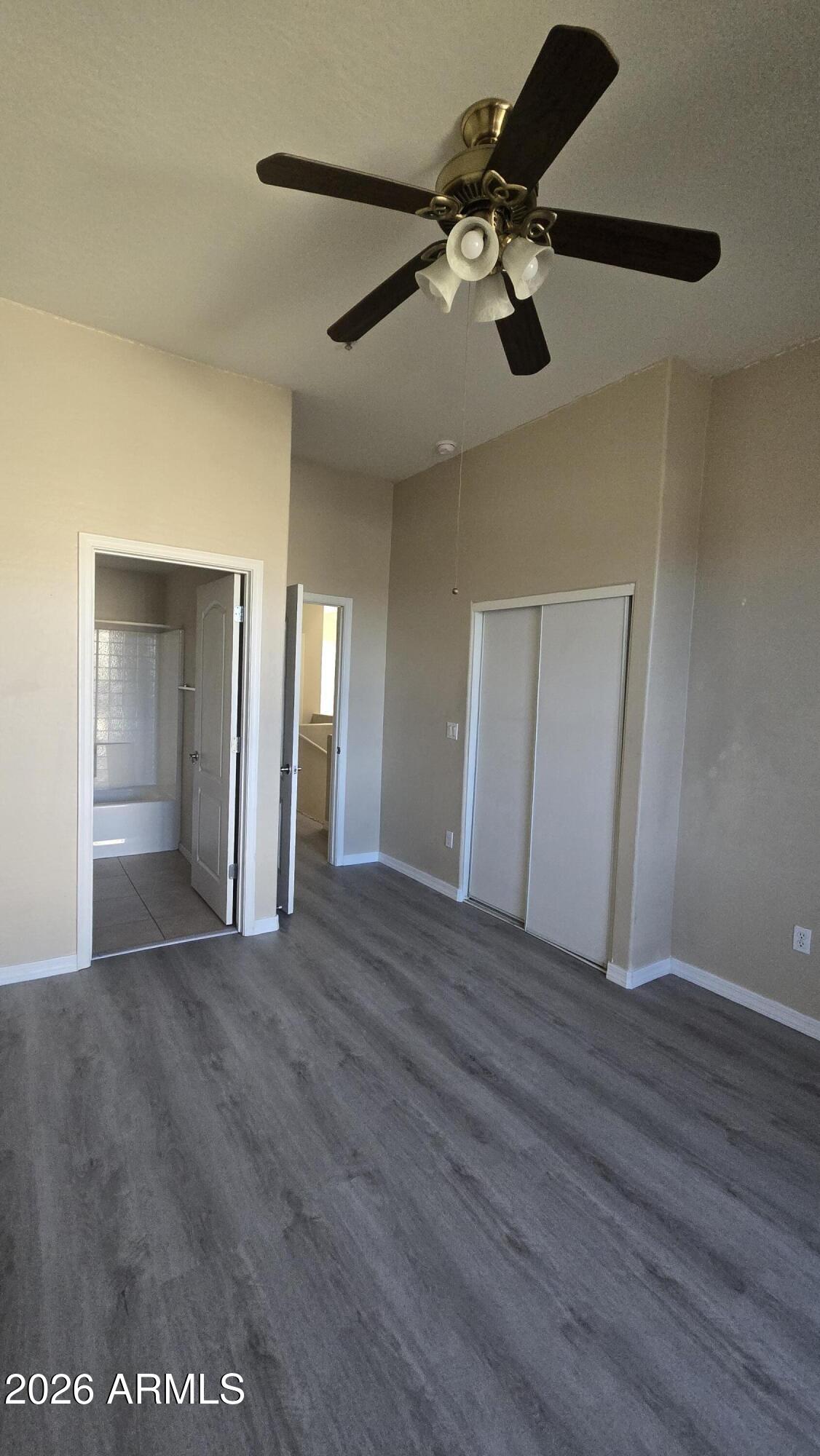 7528 North 19th Avenue, Unit 9 Phoenix, AZ 85021 - Photo 15 of 18 a view of an empty room with wooden floor and a ceiling fan