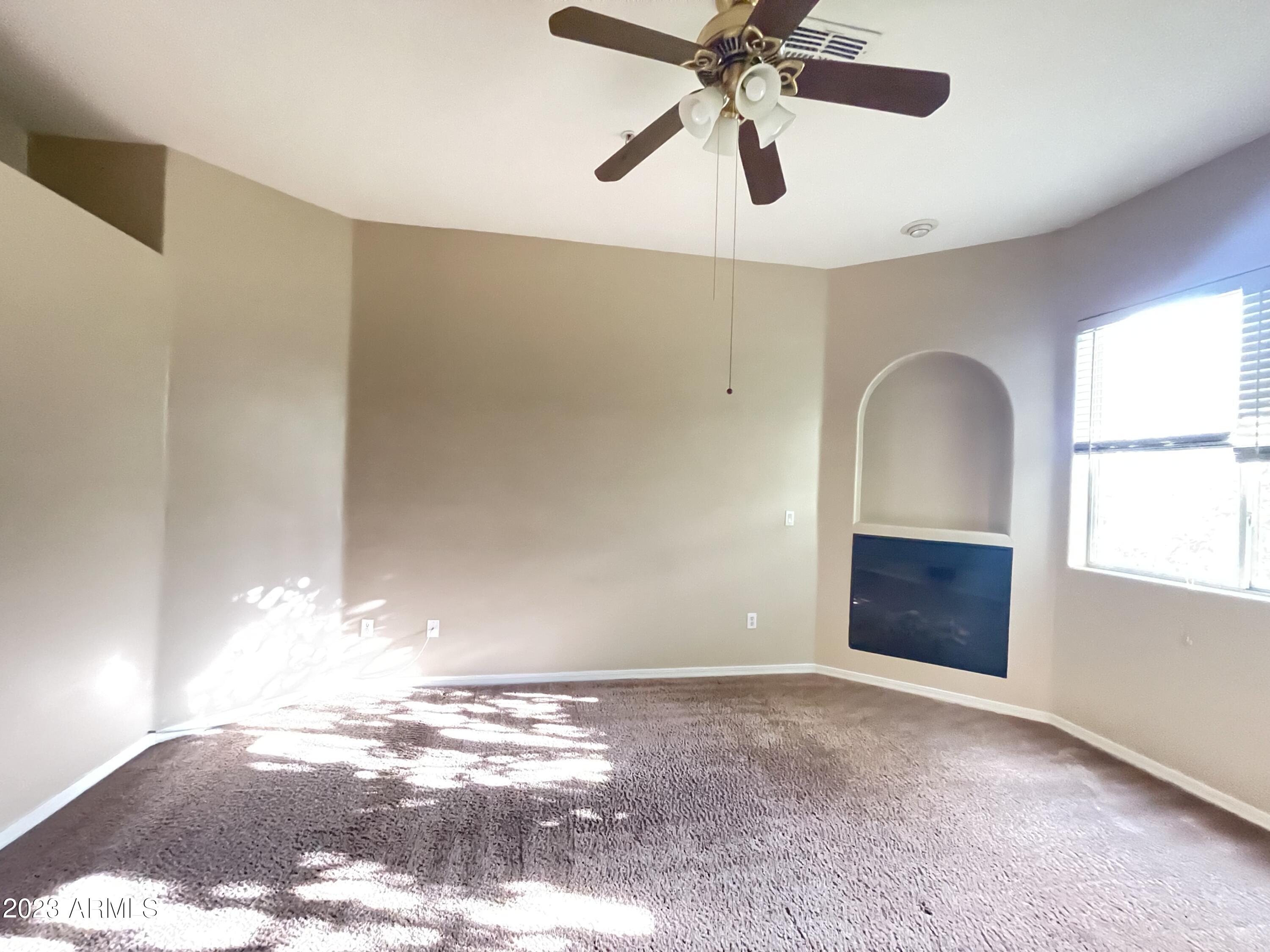 7528 North 19th Avenue, Unit 9 Phoenix, AZ 85021 - Photo 3 of 12 a view of an empty room with window and wooden floor