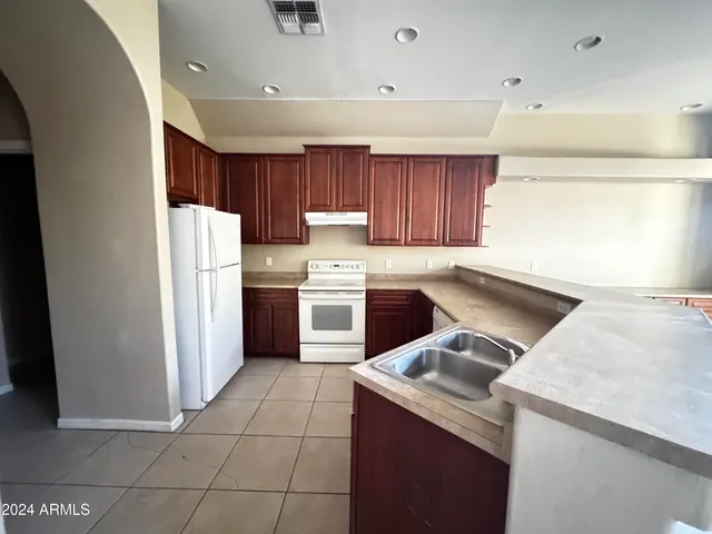 a kitchen with a sink a stove a refrigerator and cabinets