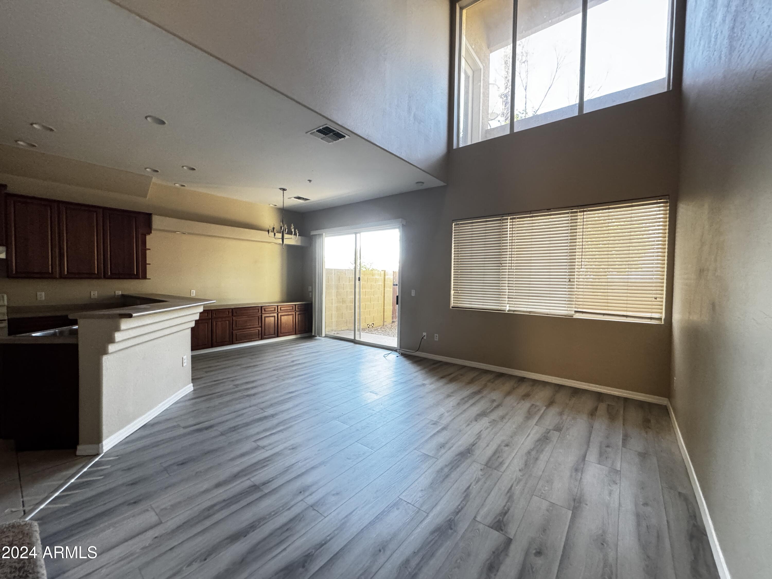 7528 North 19th Avenue, Unit 9 Phoenix, AZ 85021 - Photo 10 of 12 a view of an empty room with a window and wooden floor