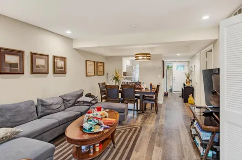 a living room with furniture a wooden floor and a flat screen tv