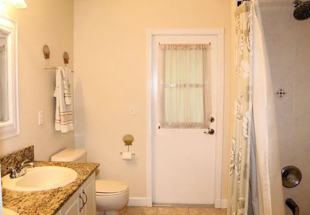 a bathroom with a granite countertop sink toilet and shower
