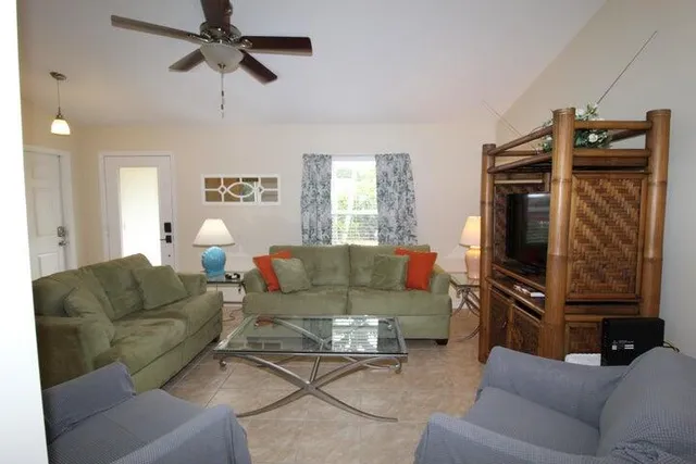 a living room with furniture a ceiling fan and a window