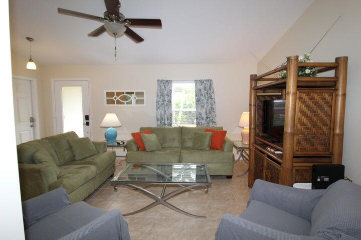 5300 Seagrape Drive Fort Pierce, FL 34982 - Photo 3 of 17 a living room with furniture a ceiling fan and a window