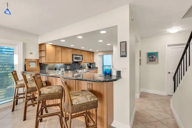a kitchen with stainless steel appliances granite countertop a refrigerator and a sink