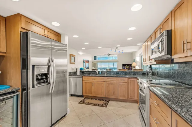 a kitchen with stainless steel appliances granite countertop a refrigerator and a sink