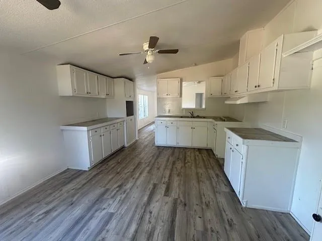 a large kitchen with cabinets and wooden floor