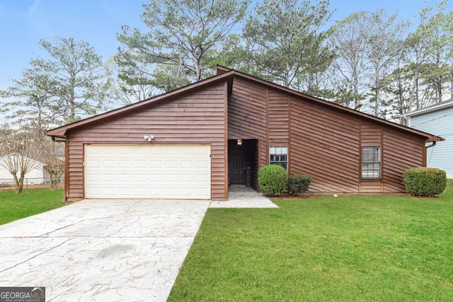 a view of a house with a yard and garage
