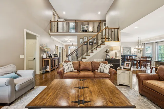 a living room with furniture kitchen view and a chandelier