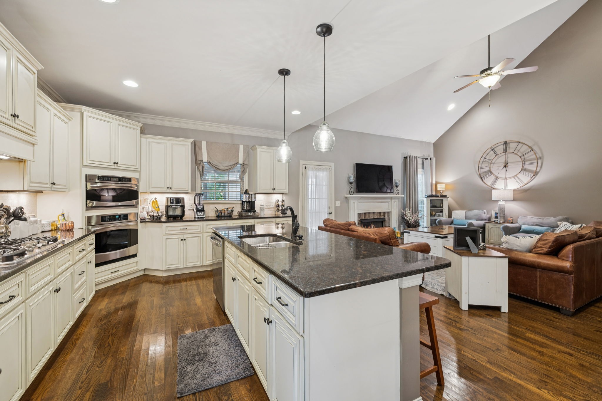 4003 Campania Strada Spring Hill, TN 37174 - Photo 18 of 50 a kitchen with stainless steel appliances granite countertop a stove top oven a sink dishwasher a dining table and chairs with wooden floor