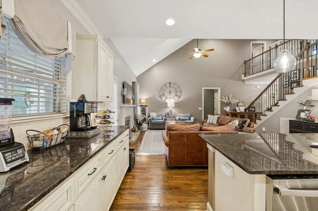 a kitchen with kitchen island granite countertop a stove sink and refrigerator