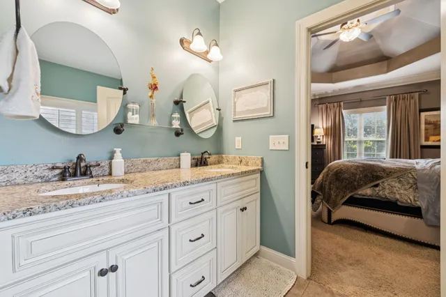 a bedroom with a bed a dresser and a chandelier