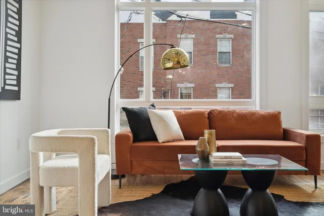 a living room with furniture a chandelier and a dining table