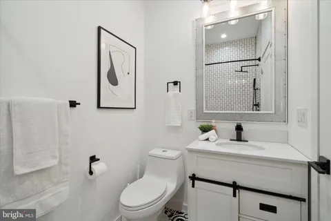 a bathroom with a sink a toilet a mirror and shower