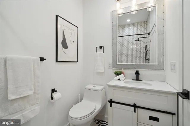 a bathroom with a sink a toilet a mirror and shower