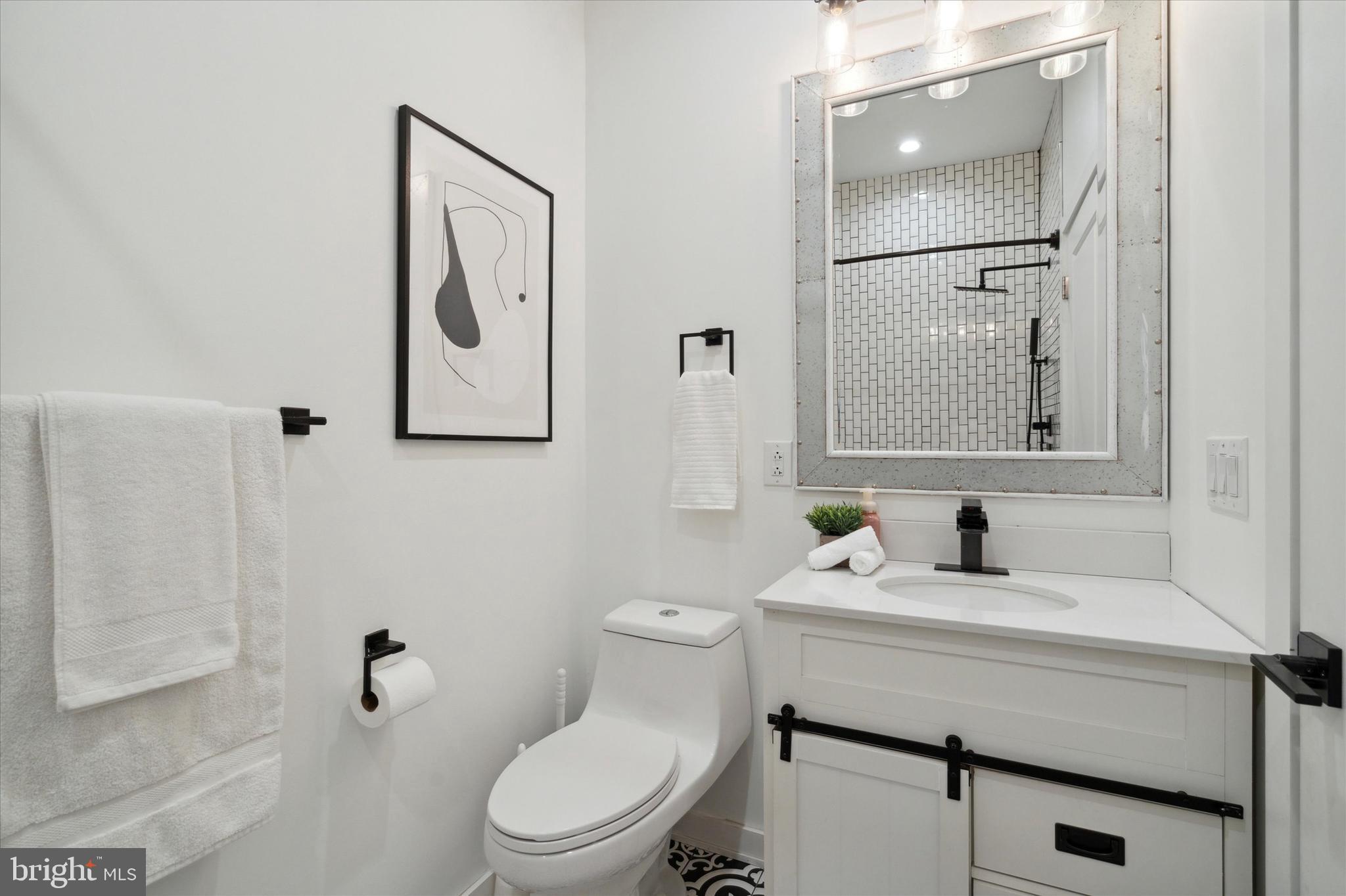 1825 Ginnodo Street, Unit R2 Philadelphia, PA 19130 - Photo 25 of 38 a bathroom with a toilet a sink and mirror
